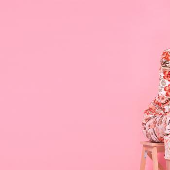 Una modelo sentada con un atuendo de flores representa el estilo de la moda colombiana.